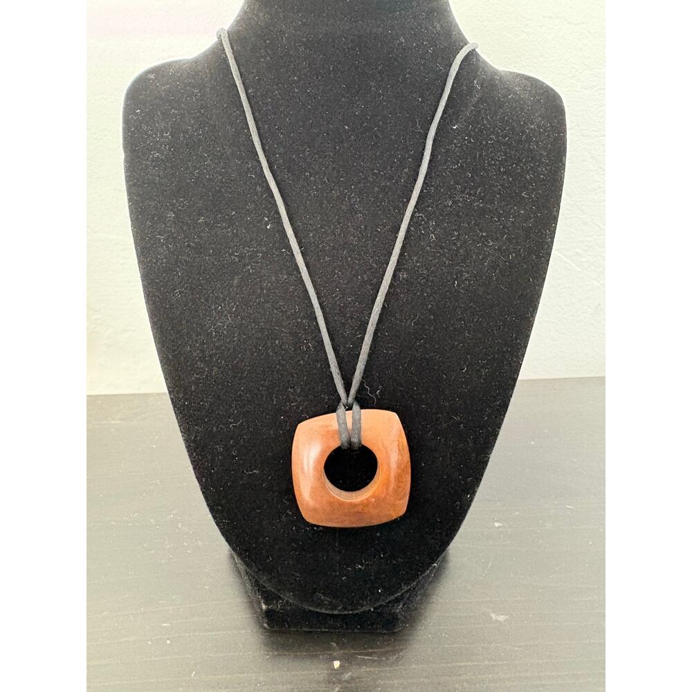 Square wood like brown necklace pendant with black fabric cord. 16 in. fashion